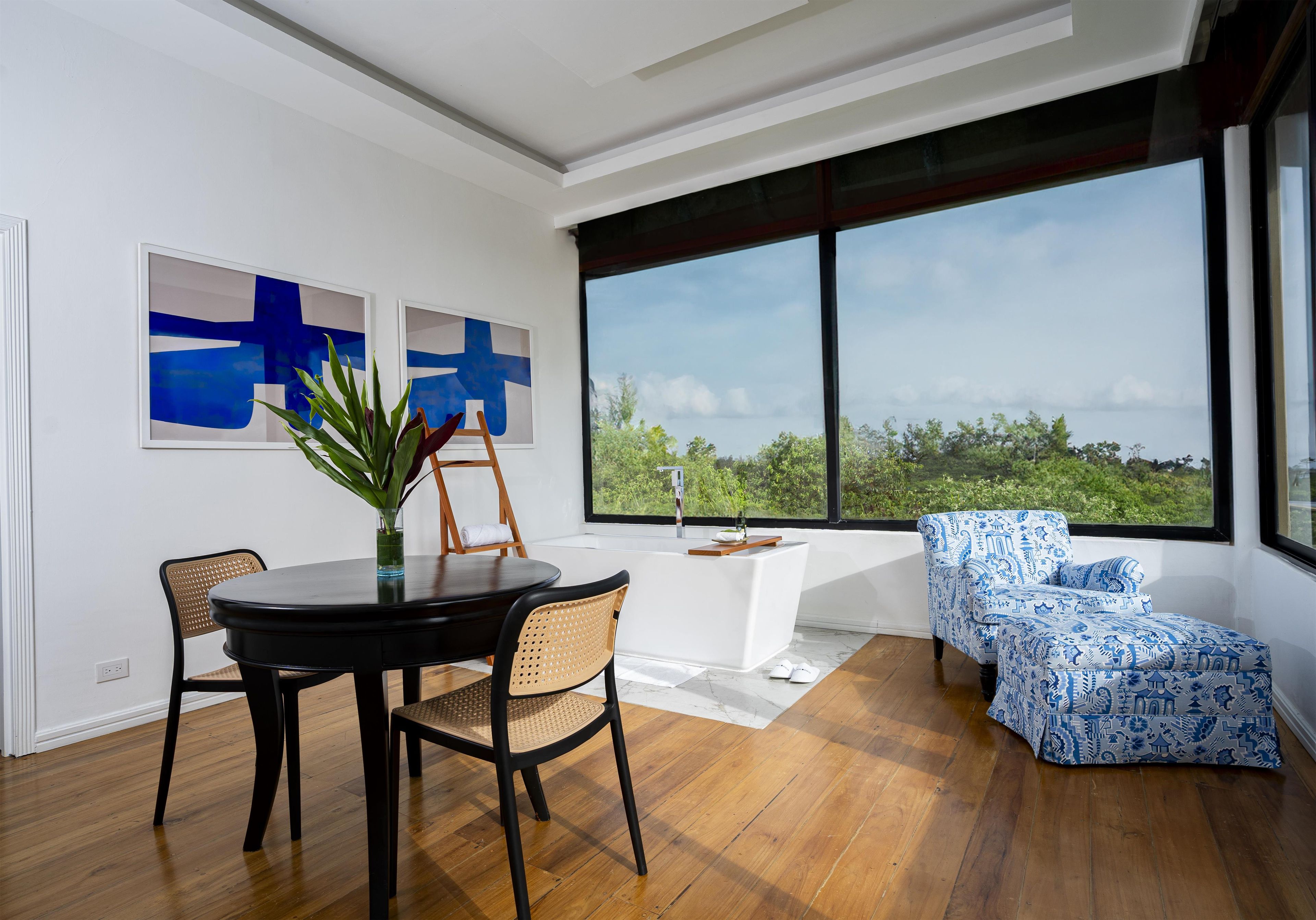 Un interior moderno con zona de comedor, área de estar con vistas y obras de arte en la pared.