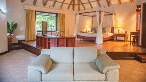 Une chambre avec un lit à baldaquin, un bureau et un canapé.