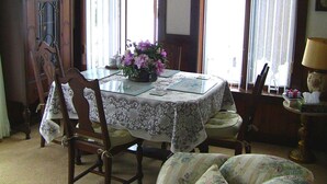 A dining area with a table set for four, surrounded by wooden chairs. - A Valley View Bed & Breakfast (Perth South)