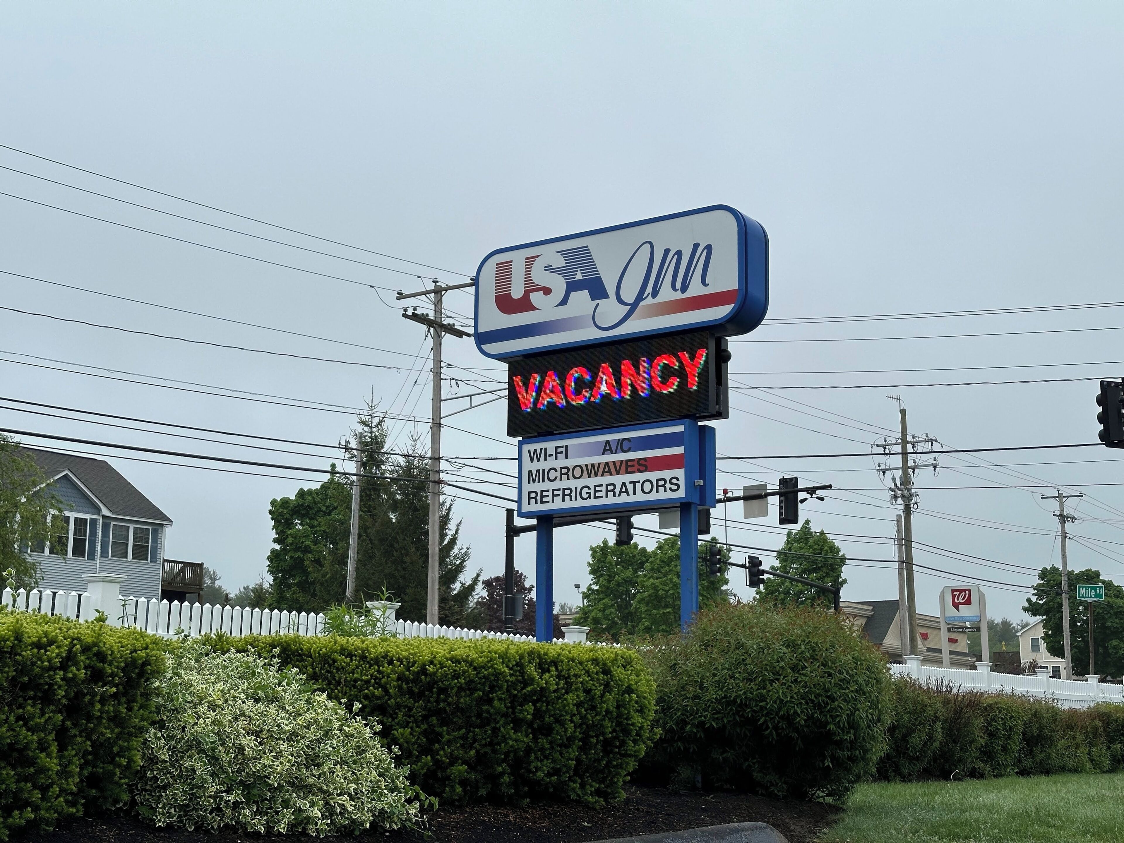 Señal de USA Inn que indica disponibilidad, con servicios que incluyen Wi-Fi, microondas y refrigeradores.