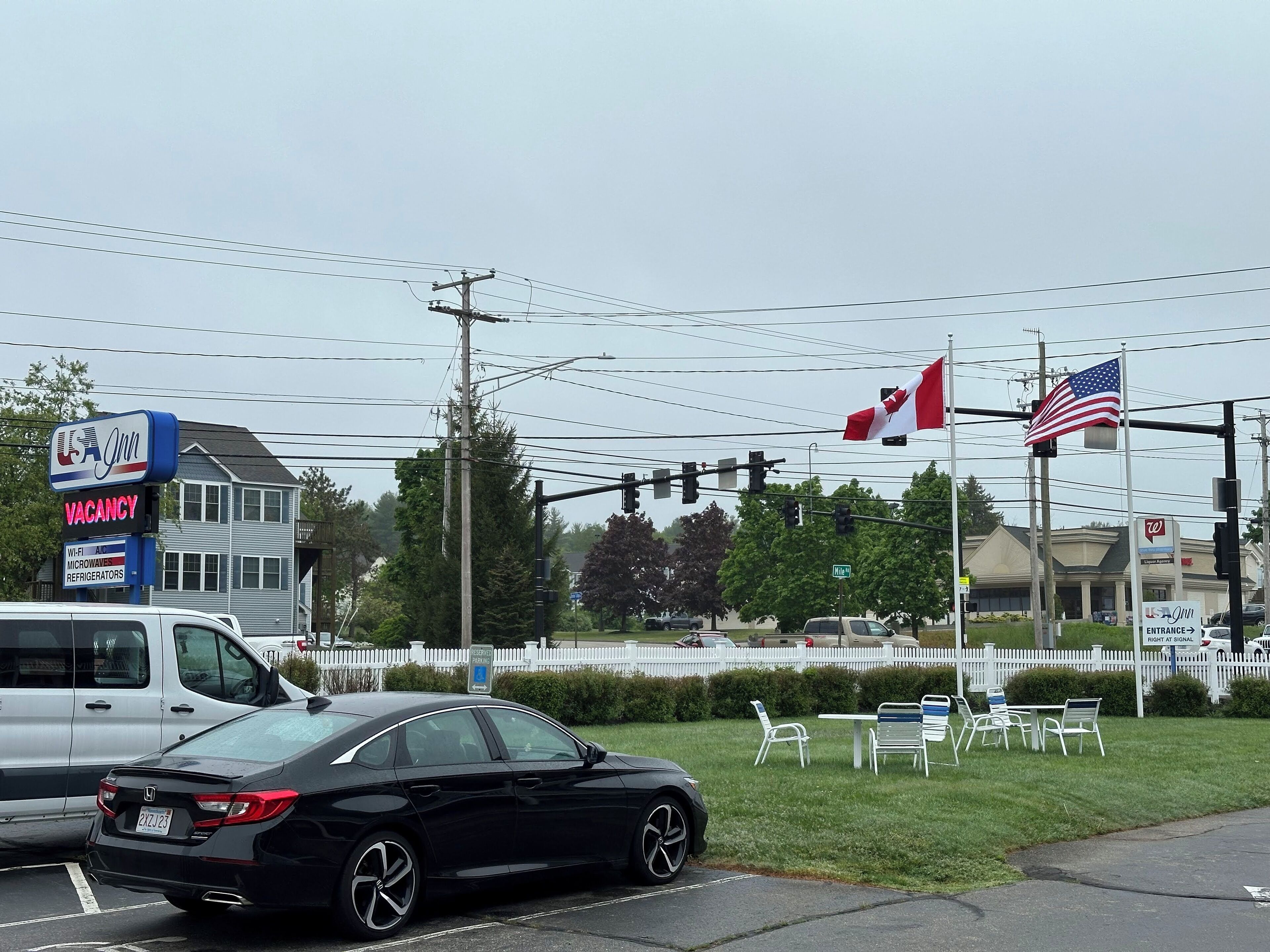 A USA Inn sign indicating a vacancy, with a parking area and outdoor seating visible.