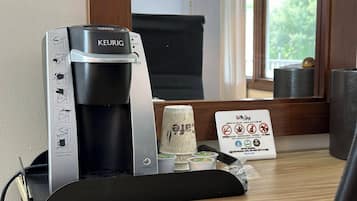 A Keurig coffee machine with instructions, a coffee pod holder, and a sign indicating no smoking, vaping, or pets allowed.