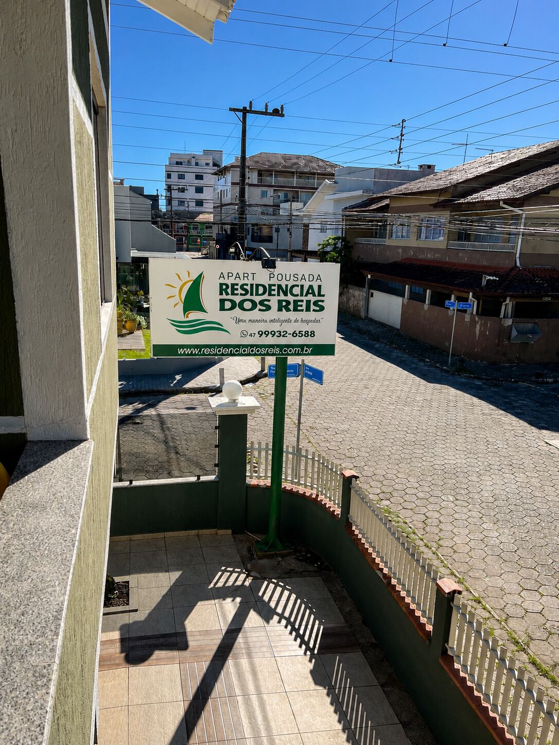 A residential property sign with contact information and a website URL.