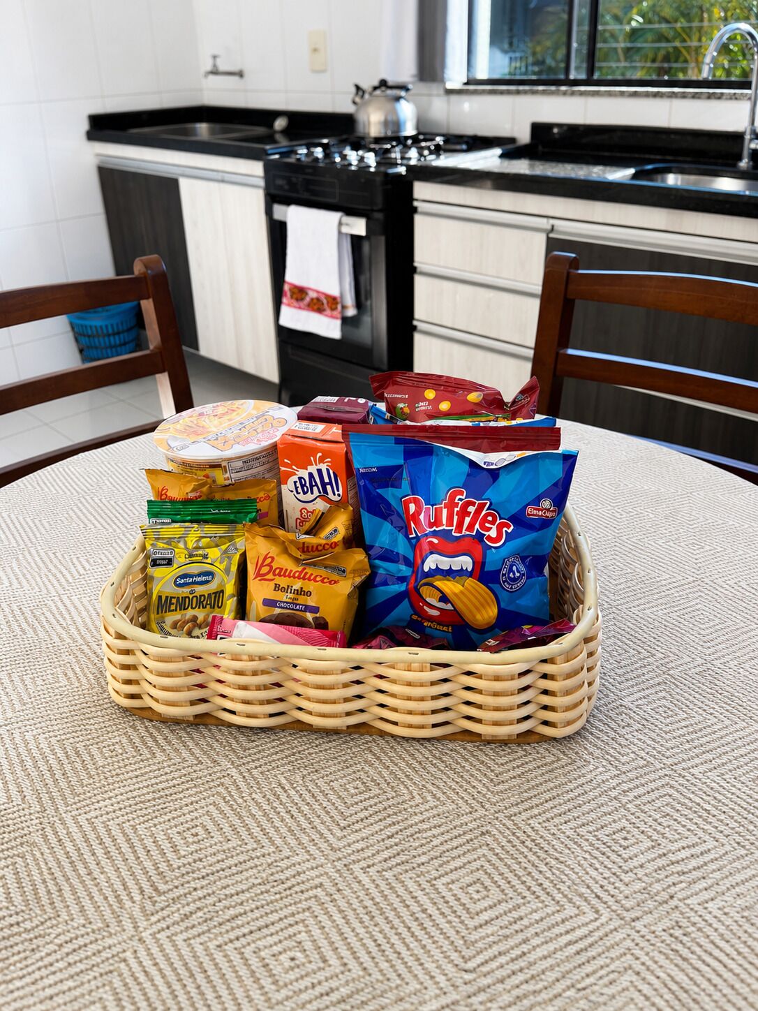 Un panier en osier rempli d’en-cas, posé sur une nappe à motifs.