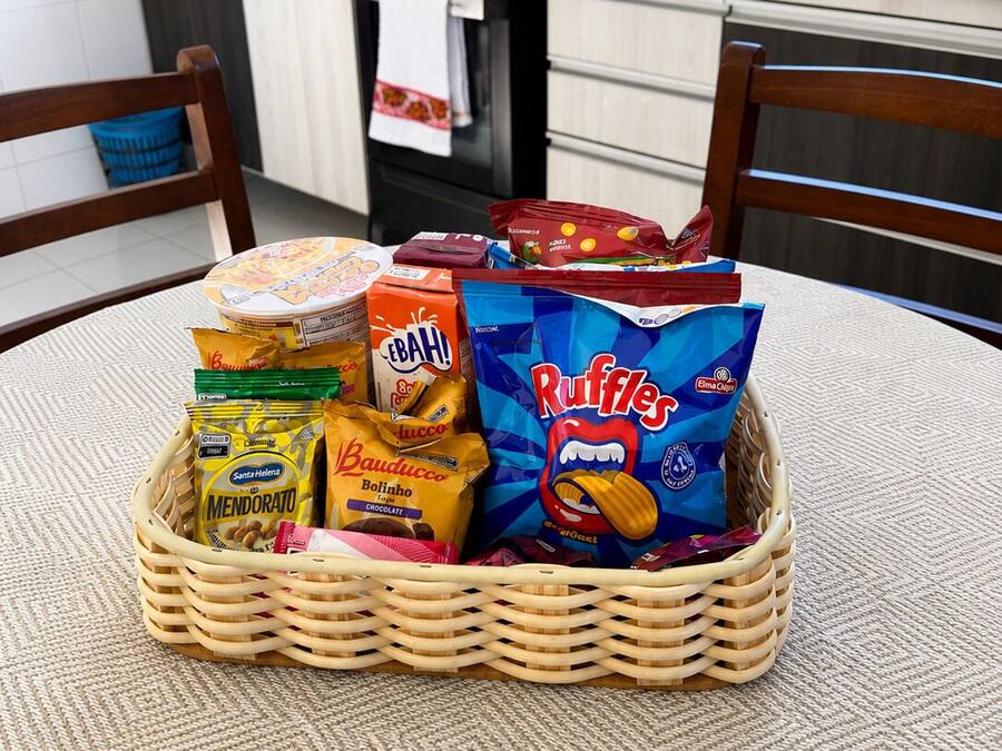Un panier en osier rempli d’en-cas, posé sur une nappe à motifs.
