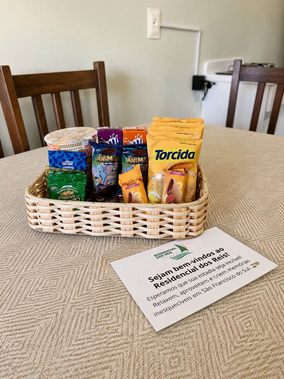 A wicker basket filled with snacks and a card on a table.