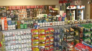 A store with shelves stocked with various products, including snacks and beverages.