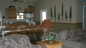 A living room with a patterned sofa, a wooden coffee table with a lamp, and a grey couch.