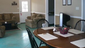A dining area with a wooden table, chairs, and a small potted plant.