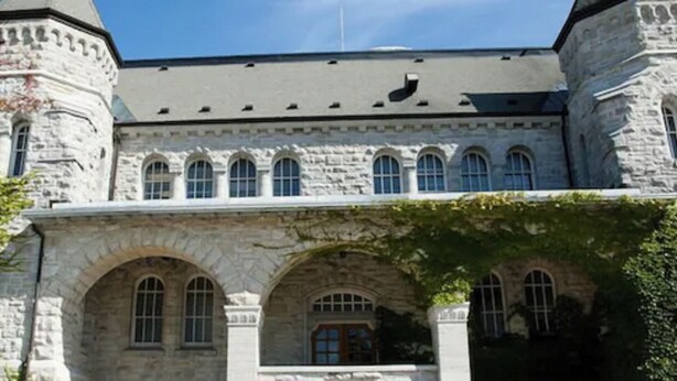 A large stone building with arched windows and a central entrance. - Queen's University - David C. Smith House - Campus Accommodation (Kingston)