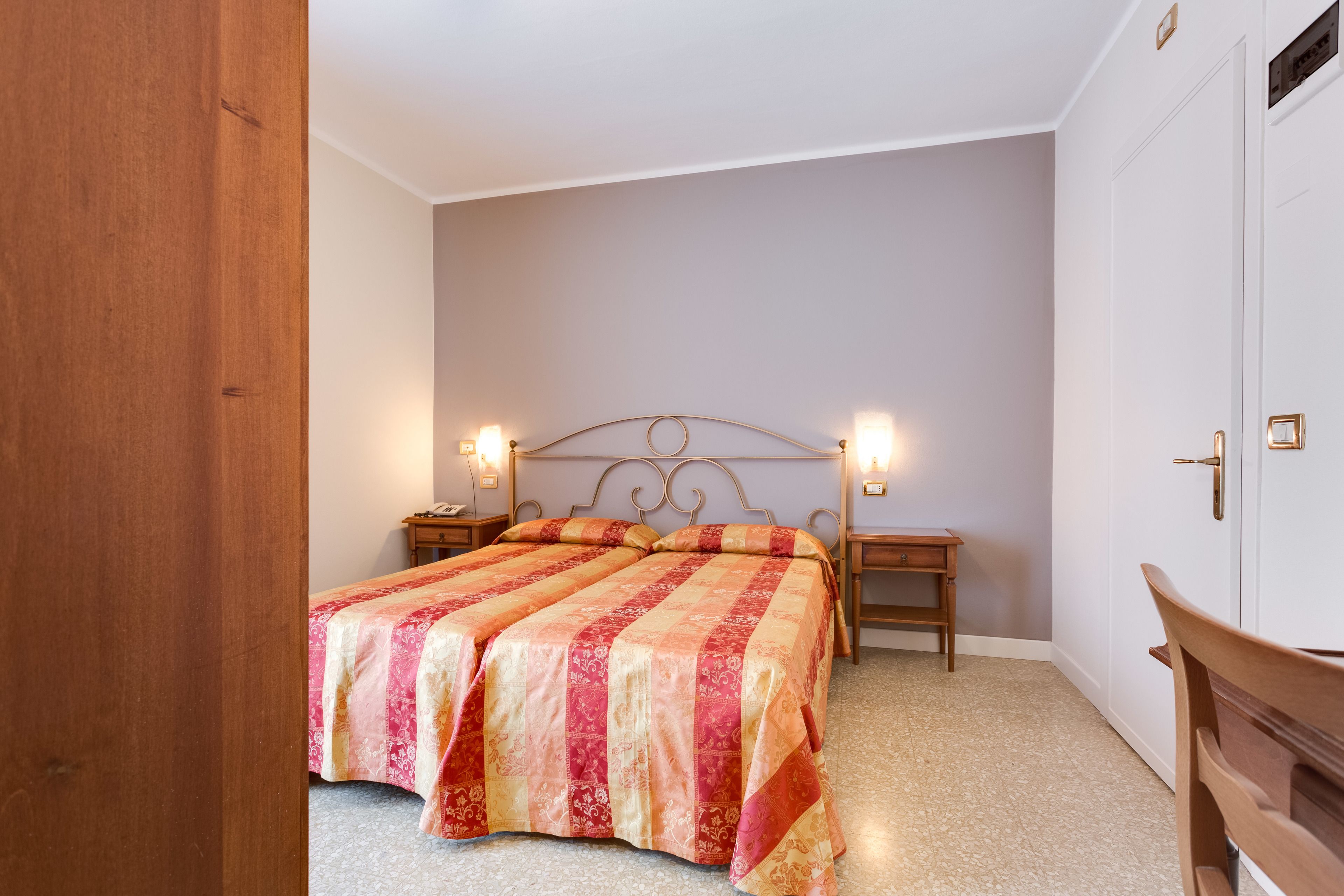 A bedroom with a bed, two bedside tables, and a nightstand.
