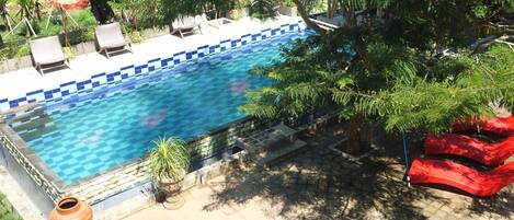 Alberca al aire libre, sombrillas en la alberca y camastros