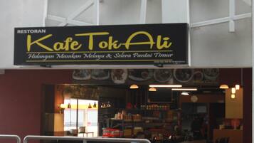 Un restaurant appelé « Kafe Tok Ali », avec une enseigne au-dessus de l’entrée.