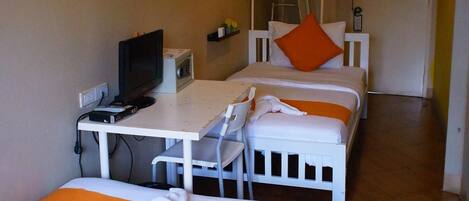 A hotel room with two beds, a desk with a computer, and a television.