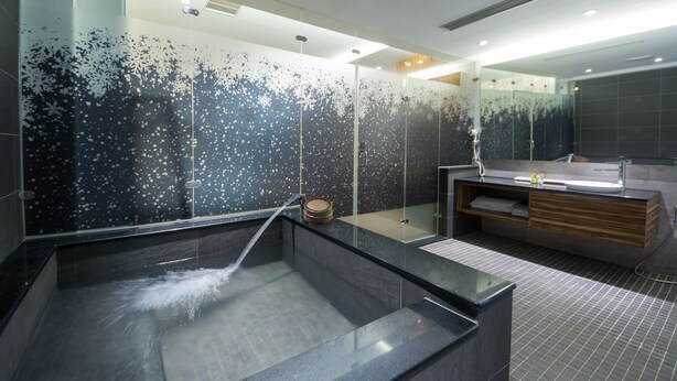 A modern bathroom with a glass-enclosed shower, a wooden vanity, and a large mirror. - Garden Spring Hotel (Jiaoxi)
