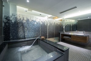 A modern bathroom with a glass-enclosed shower, a wooden vanity, and a large mirror. - Garden Spring Hotel (Jiaoxi)