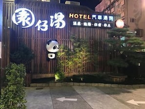 Welcome to Hotel, where traditional charm meets modern hospitality, featuring a panda mascot and lush surroundings.