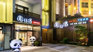 A hotel with a sign indicating it is a hotel. There are two panda statues outside the entrance. - Garden Spring Hotel (Jiaoxi)