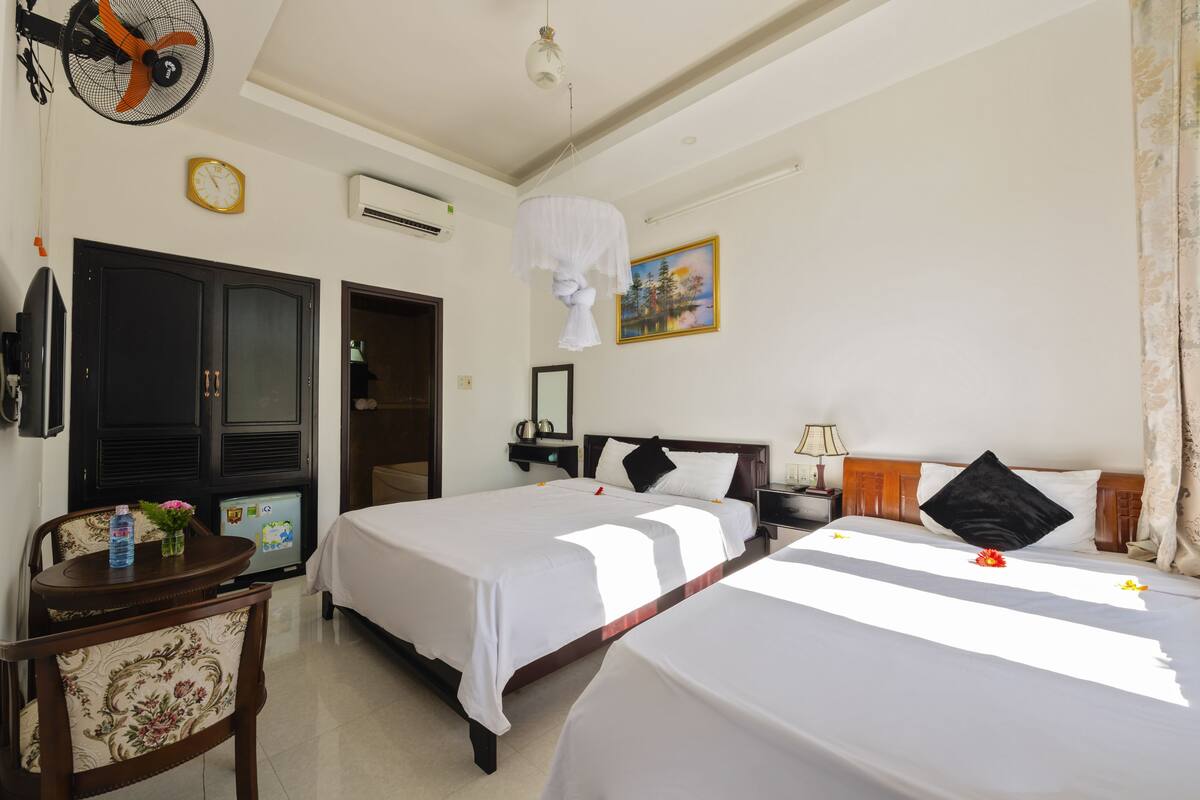 Deluxe Triple Room | Minibar, in-room safe, desk, blackout drapes