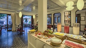 Vestíbulo de hotel con zona de buffet, arreglos de asientos y patrones decorativos en el techo.