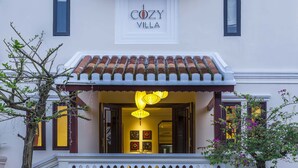 Un edificio con un cartel que dice "COZY VILLA" sobre la entrada.