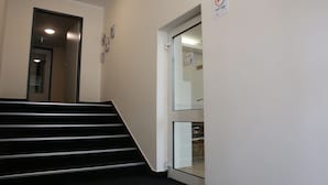 A staircase leading to a room with a glass door, a sign indicating a bike storage area, and a door with a handle. - City-Pension Magdeburg (Magdeburg)