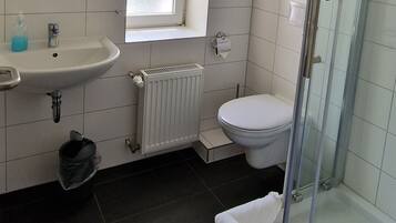 A modern bathroom with a sink, toilet, and glass shower enclosure.