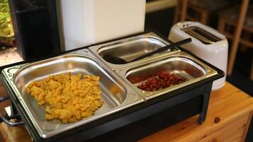 A buffet setup with scrambled eggs and red beans on a stainless steel tray.