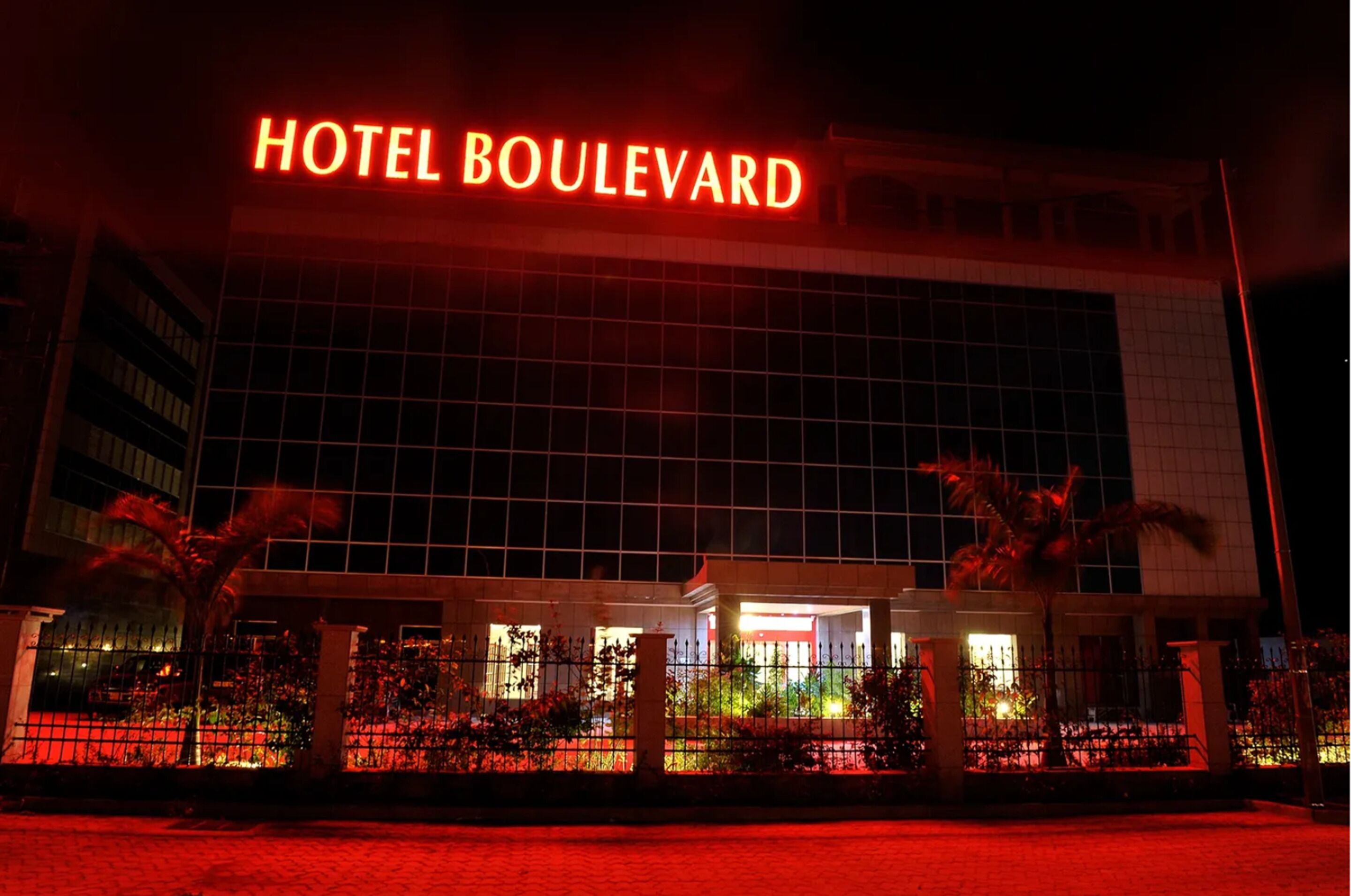 Ein Hotel mit einem gut sichtbaren 'HOTEL BOULEVARD' Schild, großen Fenstern und einem gut beleuchteten Eingang.