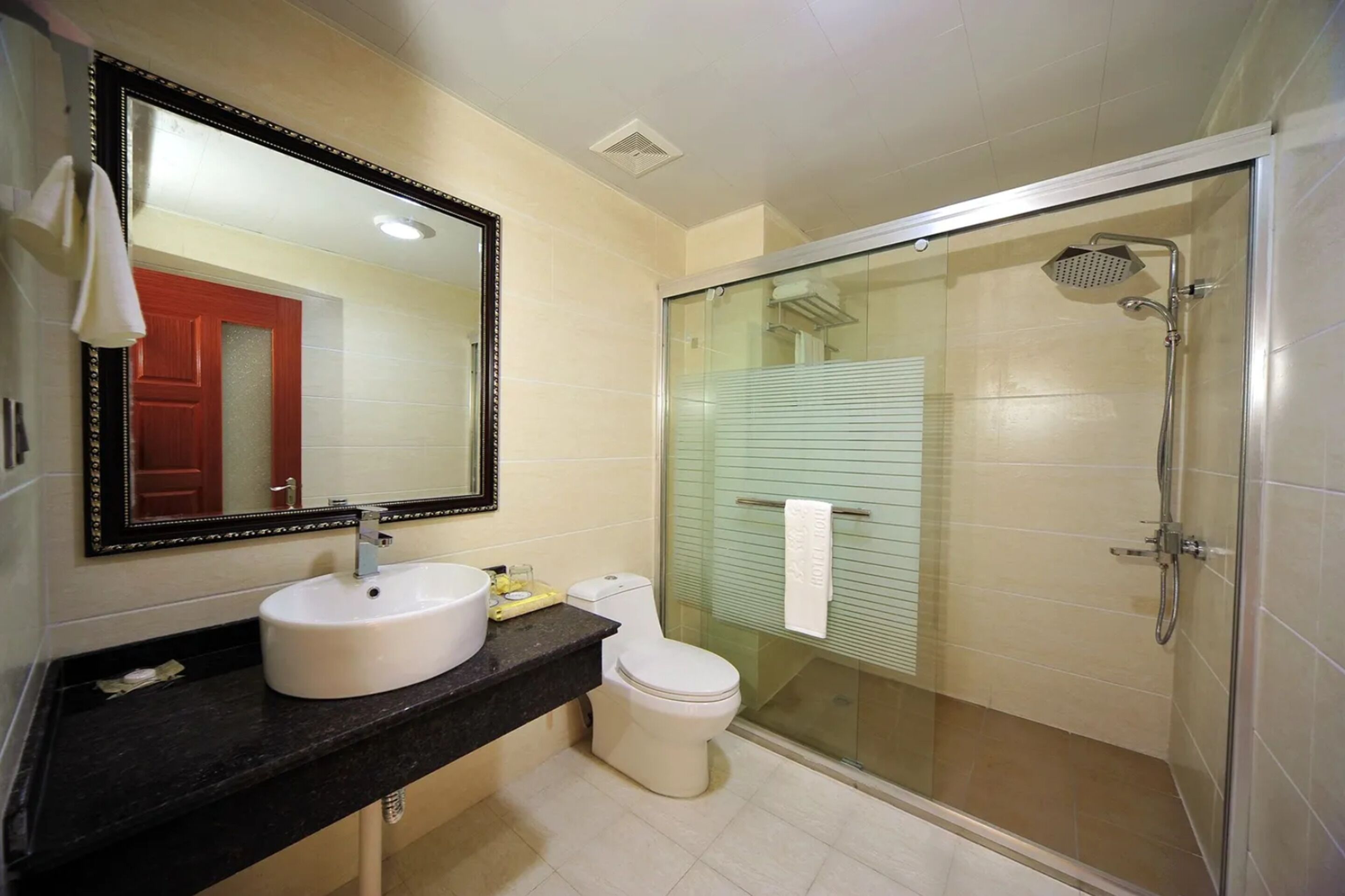 A bathroom with a sink, toilet, and glass-enclosed shower.