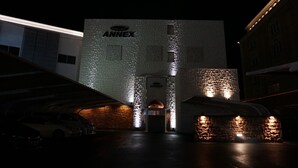 Un edificio con el letrero 'ANNEX' en la entrada, que presenta un diseño moderno con patrones iluminados en la fachada.