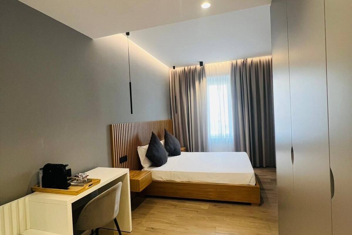 A compact hotel room with a bed, a desk, and a chair.