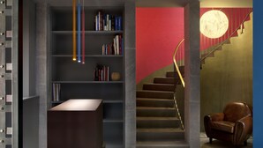 A modern interior with a bookshelf, a desk, a staircase, and a leather armchair. - La Chambre Milano (Milan)