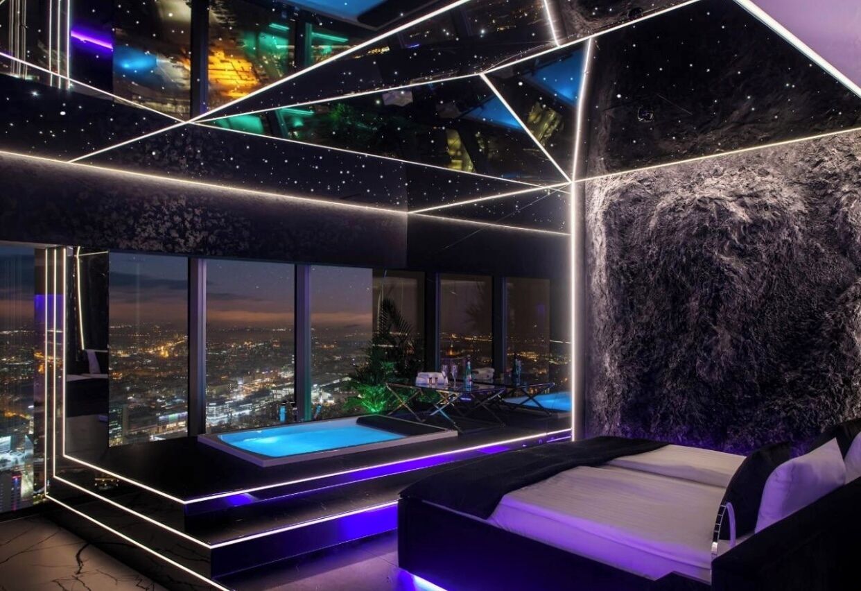 Ein modernes Schlafzimmer mit Blick auf die Stadt, einem kleinen Pool und einem einzigartigen geometrischen Deckenstil.