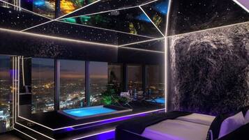 Ein modernes Schlafzimmer mit Blick auf die Stadt, einem kleinen Pool und einem einzigartigen geometrischen Deckenstil.