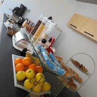 Un bufé con diversas opciones de comida, incluyendo frutas, pan y salsas.