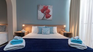Ein Hotelzimmer mit einem Bett, zwei Nachttischen, einem Bild und Handtüchern.