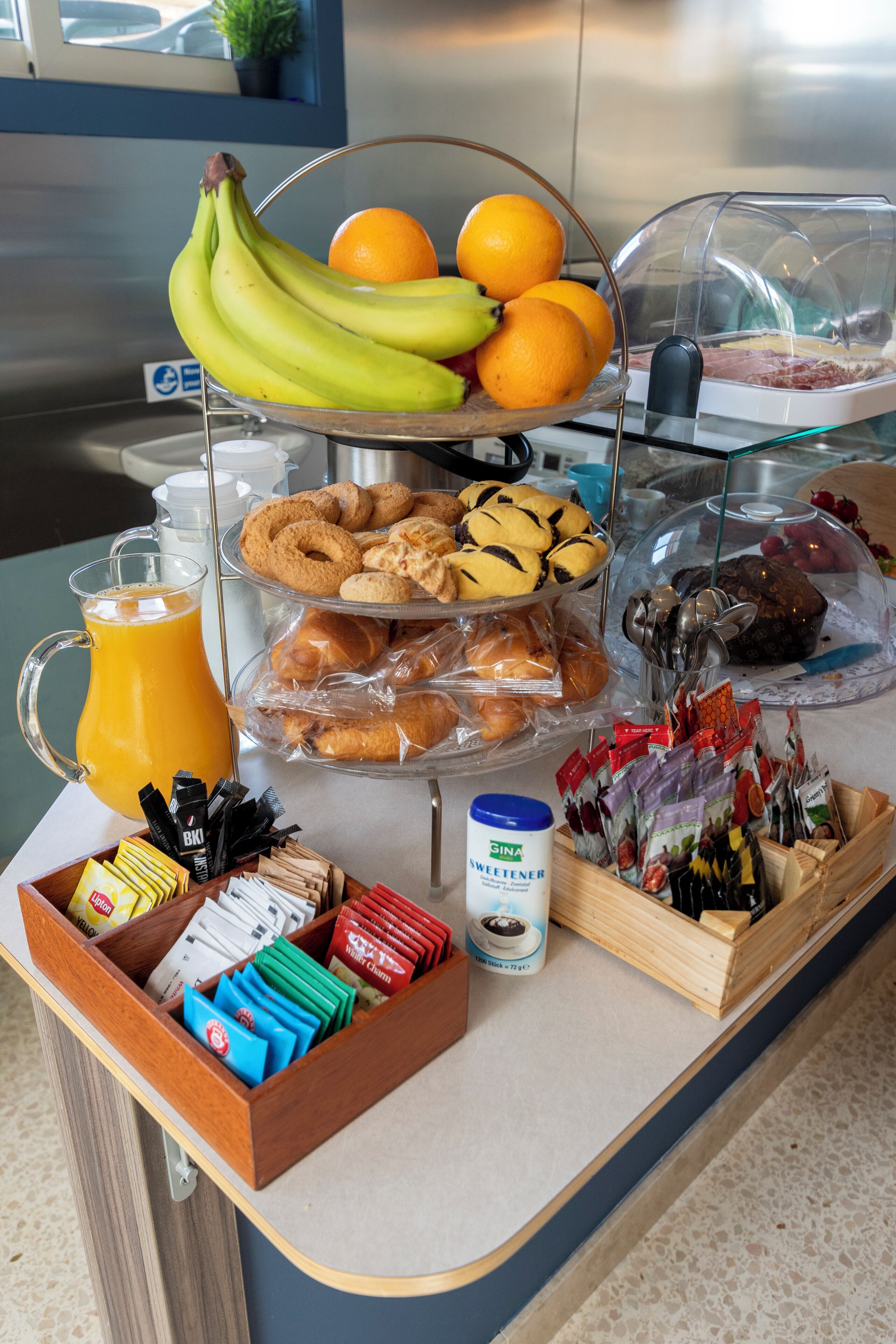 A breakfast buffet with various food items, including fruits, pastries, and condiments.