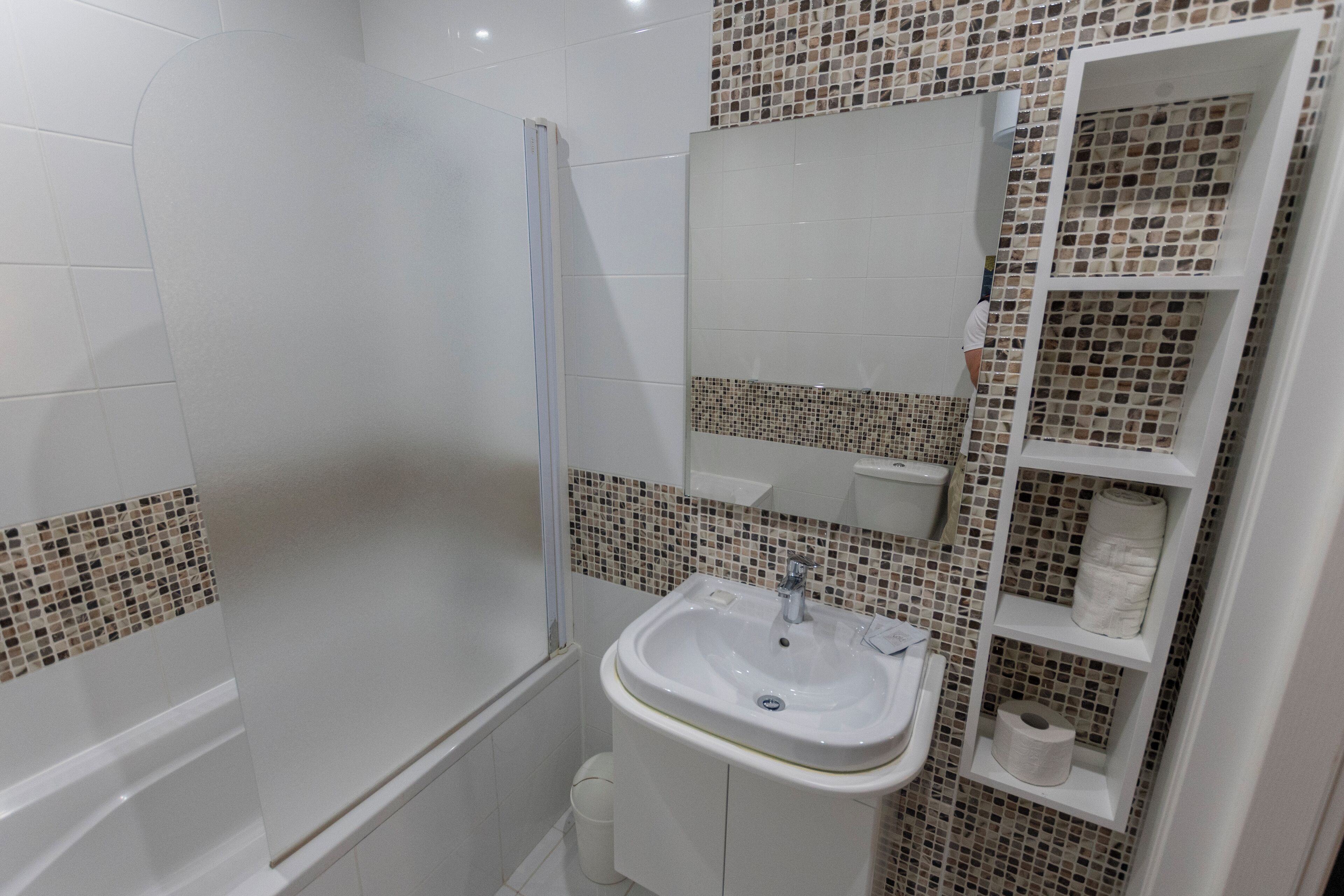 A bathroom with a shower, a sink, and a toilet.