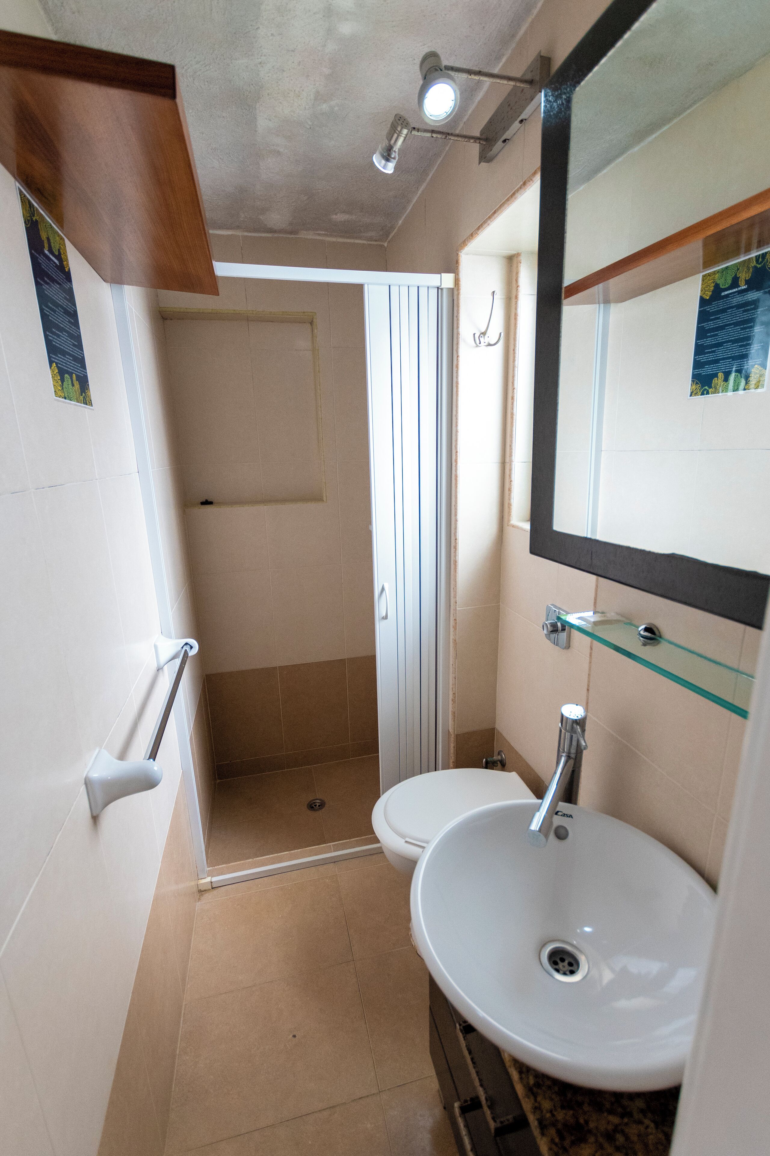Un bagno piccolo con il water, un lavandino e una doccia.