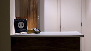 A reception desk with a rating sign, a phone, and a small card holder. - Estrella Lodging (Rabat)
