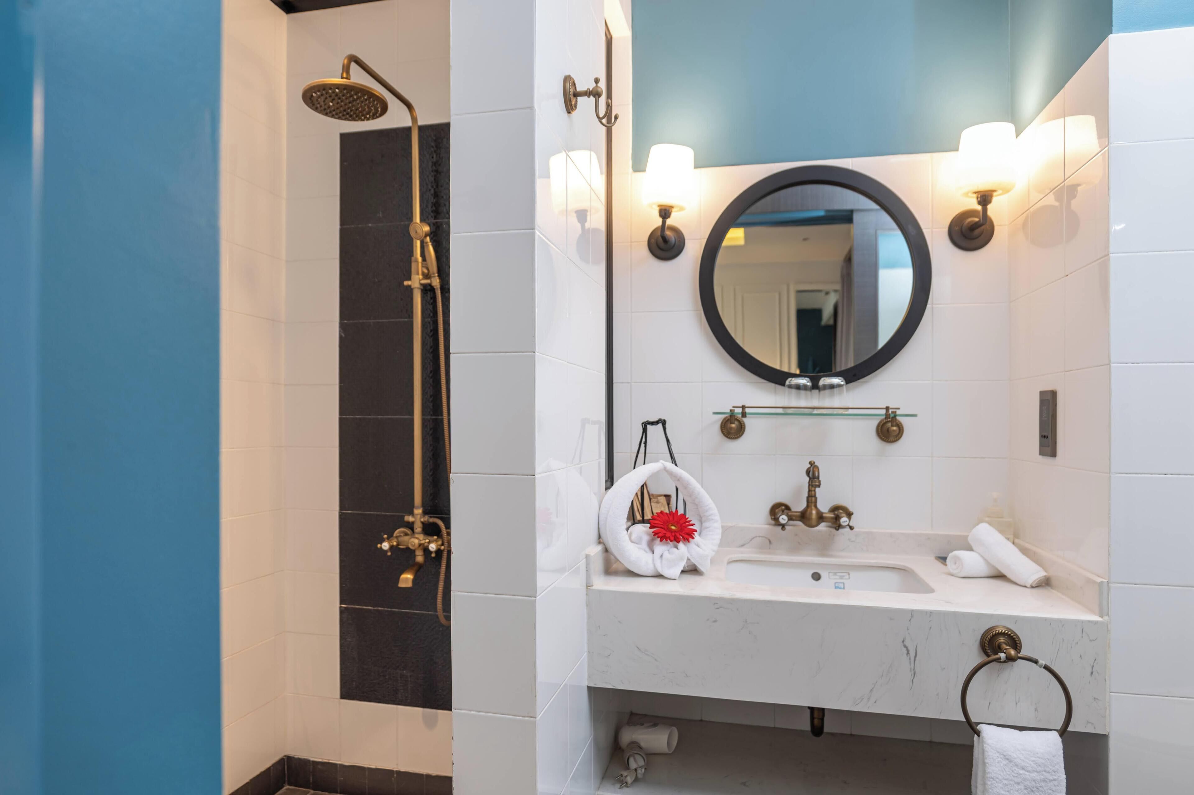 A bathroom with a shower, sink, and mirror.