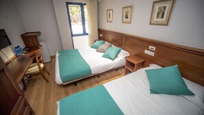 A hotel room with two beds, a wooden desk, a chair, and a window with curtains. - Hotel Alba (Soria)