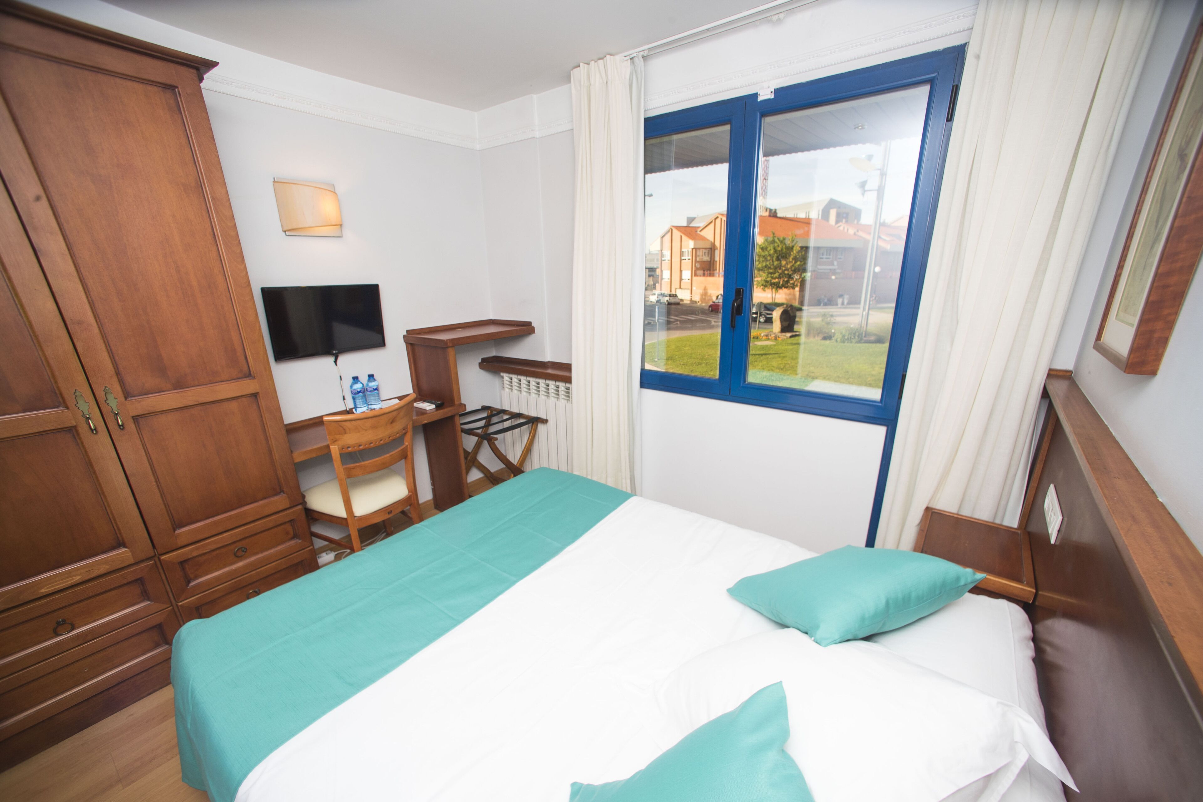 Luxe beddengoed, donsdekens, een bureau, verduisterende gordijnen