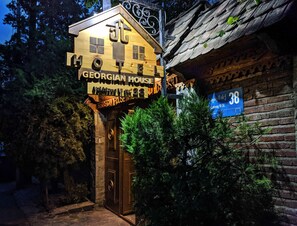 Uma casa georgiana com fachada de madeira e uma placa indicando o número.
