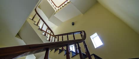 A multi-level interior with a wooden staircase and a skylight.