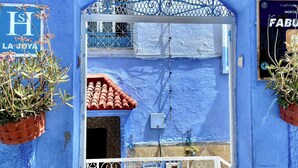 Ein Hotel mit blauem Fassadenbau, einem roten Ziegeldach und einem Schild mit der Aufschrift 'HOTEL'.