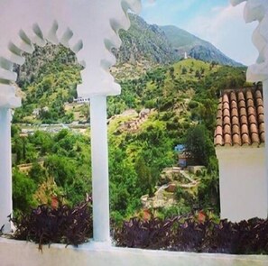A view of a mountainous landscape with greenery and a white building with a tiled roof. - Hostal La Joya (Chefchaouen)
