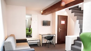 A modern interior with a staircase, a green chair, a desk, and a couch. - b_smart motel Basel (Basel)