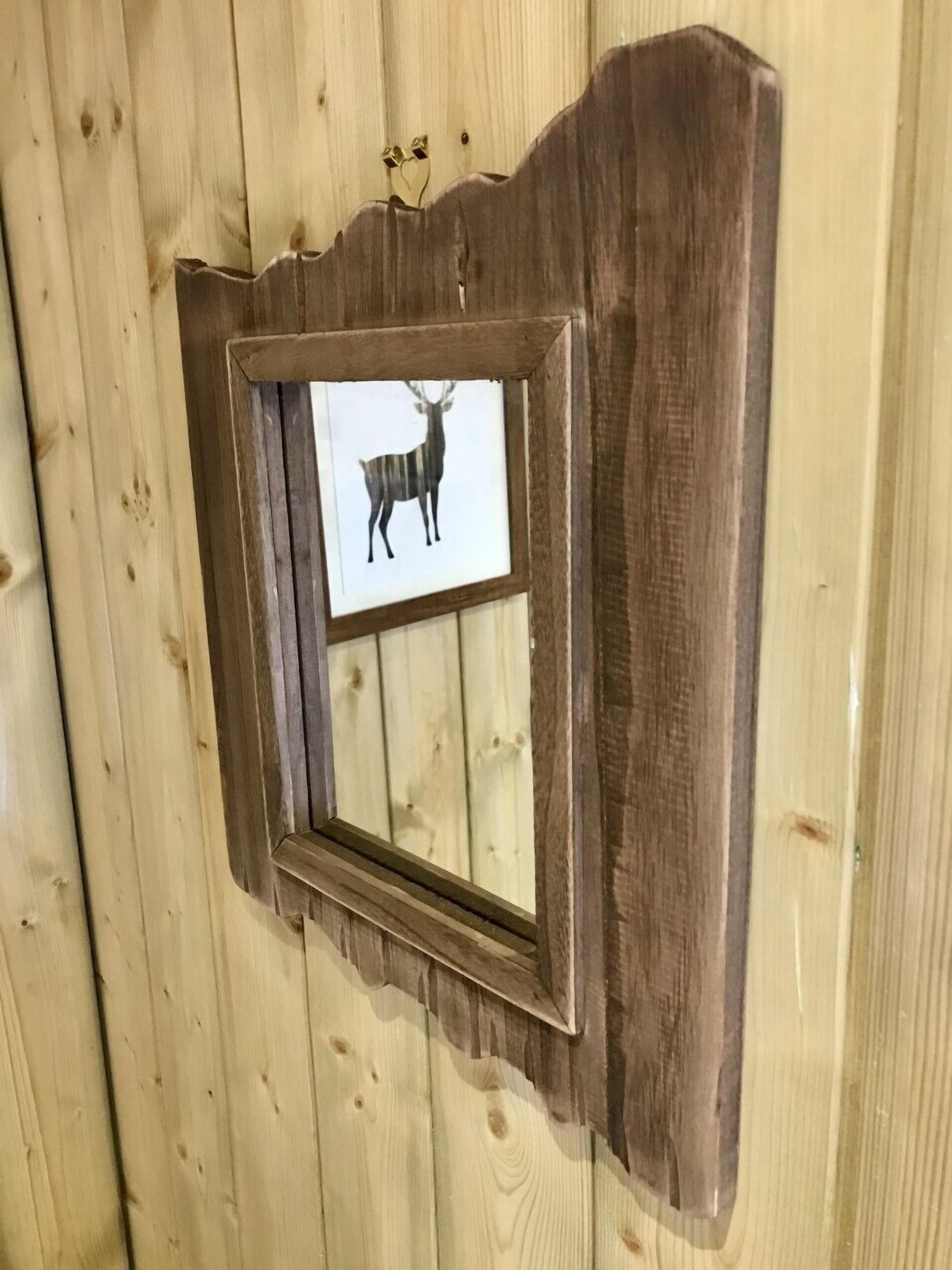 A wooden wall with a framed picture of a deer.